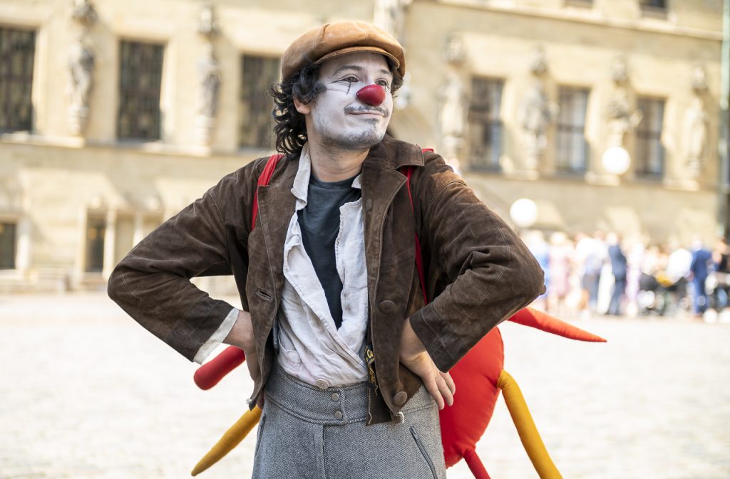 Ein Clown steht mit Händen in den Hüften in der Osnabrücker Altstadt